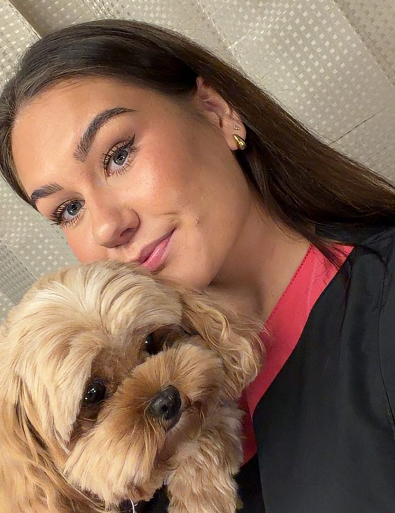 Filippa med en nyklippt hund i famnen
